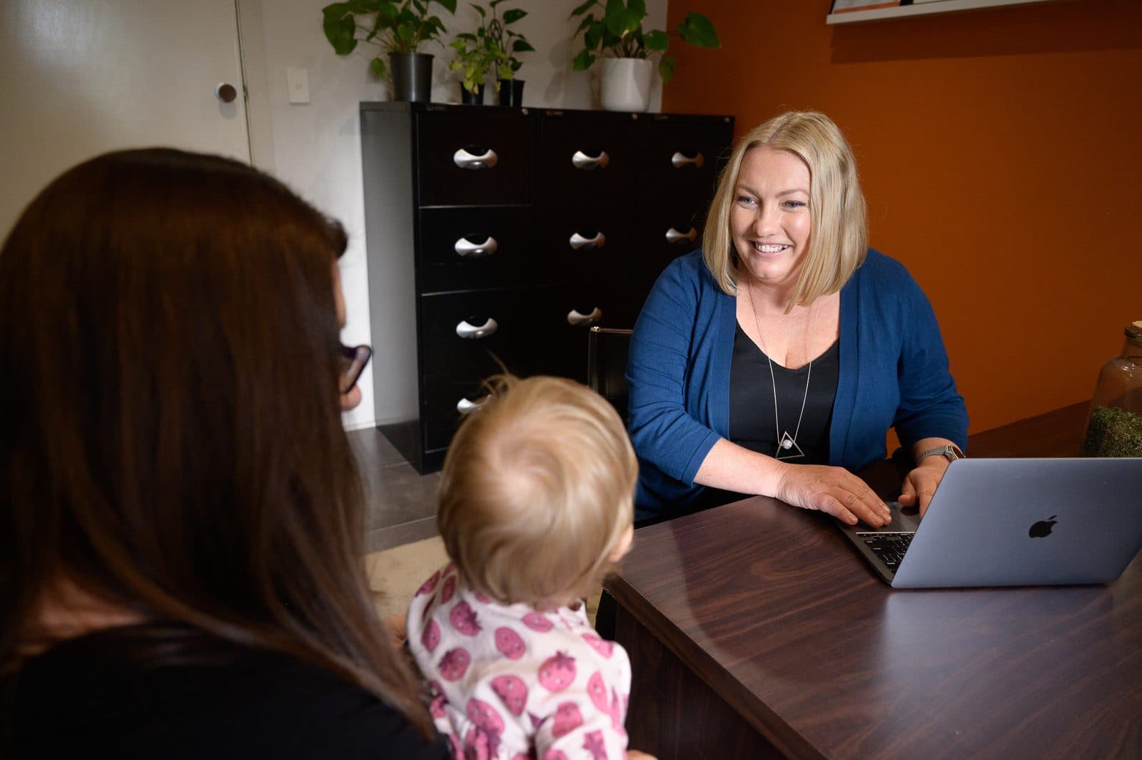Naturopath consulting with a parent and young child in clinic